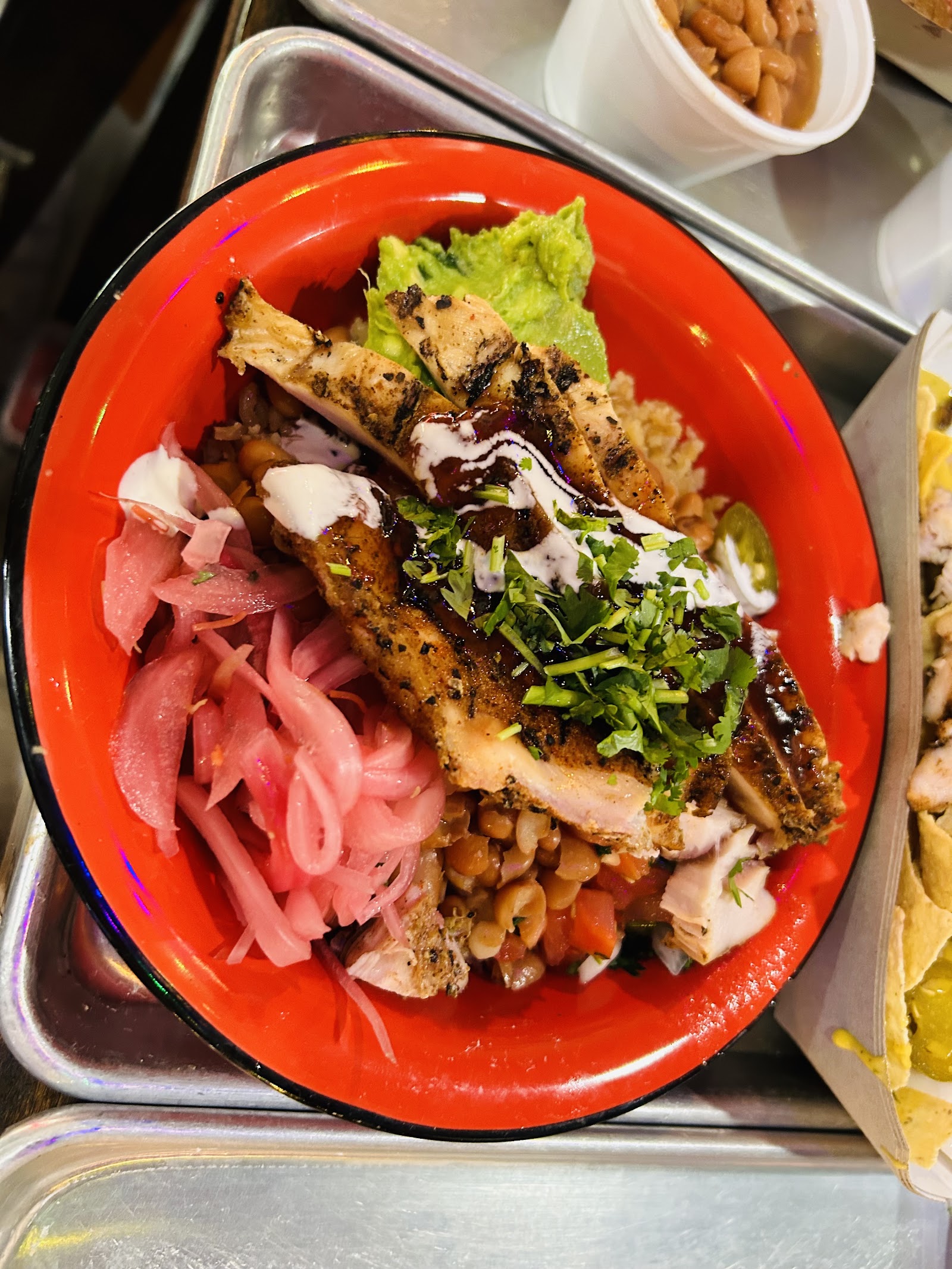 Grilled chicken bowl with guacamole, pickled onion, and beans